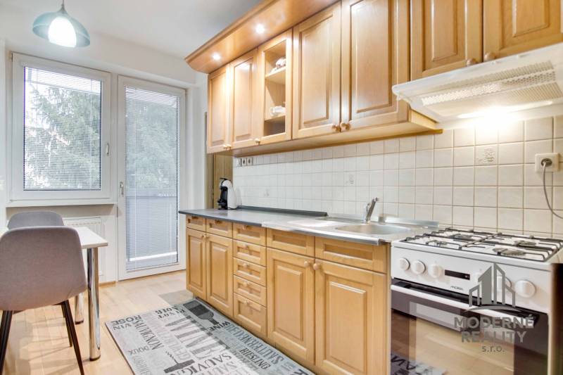 Konyha egy 4 szobás lakásban, fa dekor padlóval és étkező sarokkal.