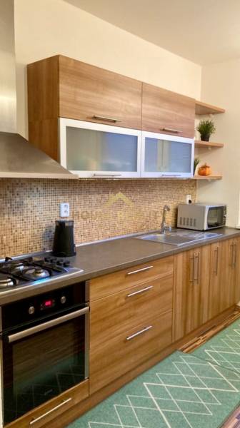 Konyha fa dekorációval és beépített készülékekkel egy háromszobás lakásban.