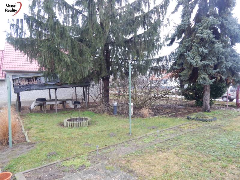 Családi ház kertje Dunamocs községben, filagóriával és tűlevelű fákkal.