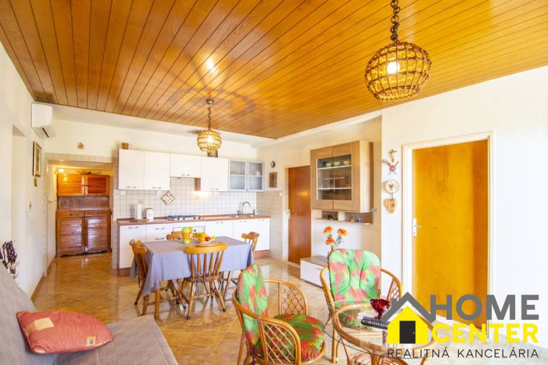 Nyaraló apartman konyhával, étkezőasztallal és fa dekorációjú padlóval.