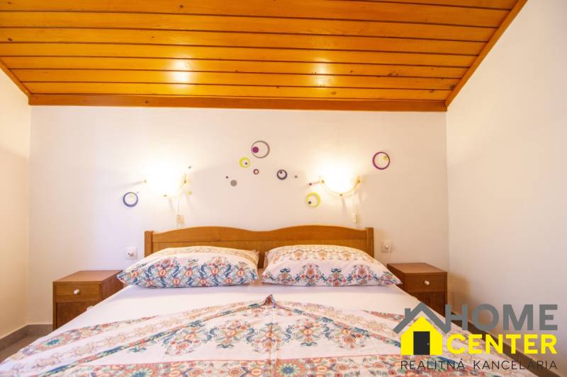 Hálószoba a nyaraló apartmanban ággyal és dekorációkkal a fehér falon.