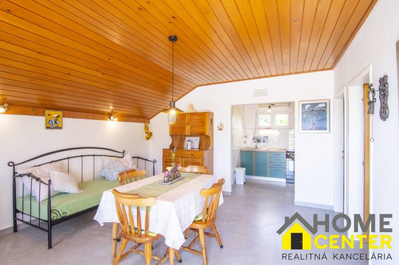 Nyaraló apartman fa dekor padlóval, étkezőasztallal és konyhával.