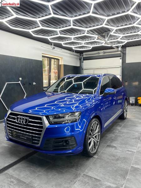 Audi SUV kereskedelmi helyiségekben csempézett padlóval és geometrikus mennyezeti világítással.