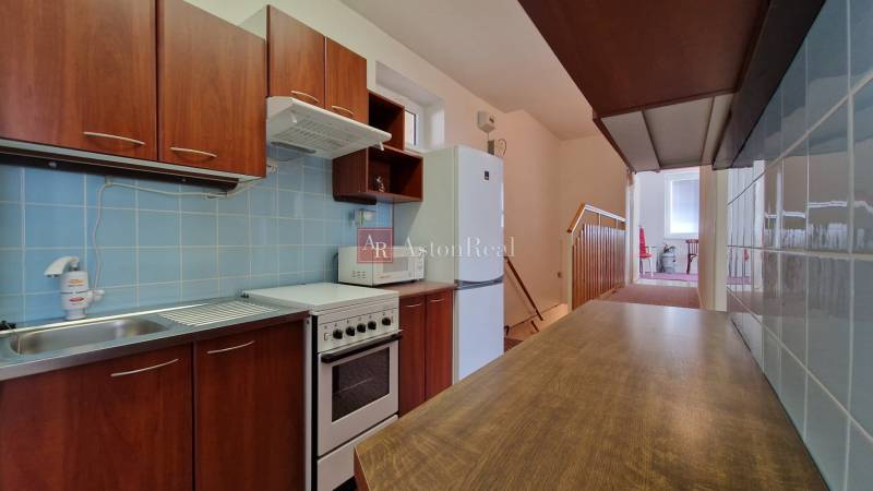 Konyha családi házban fa dekorral, kék csempékkel és konyhabútorral.