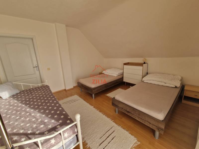 Hálószoba családi házban három ággyal és fa dekorációjú padlóval.