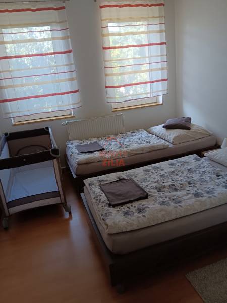 Gyerekágy és két ágy a hálószobában, fa dekorációjú padlóval.