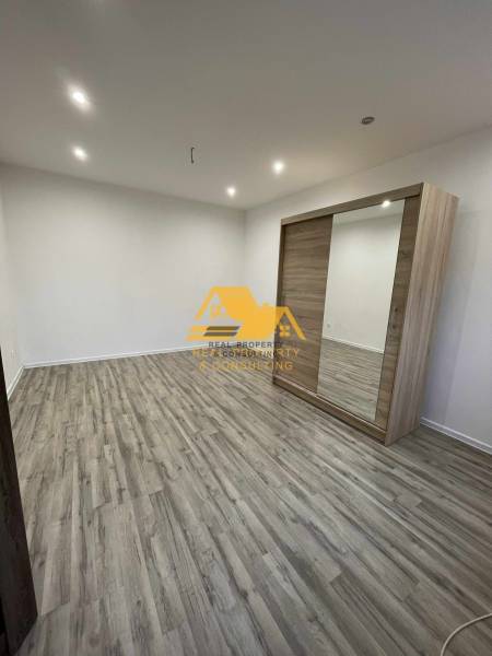 1 szobás lakás belső tere fa dekor padlóval és beépített szekrénnyel.