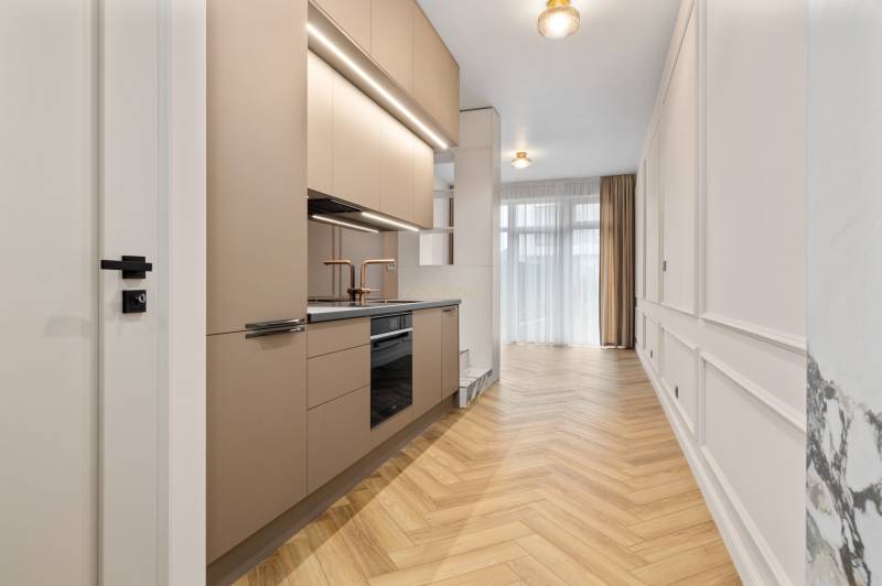 Konyha egy kétszobás lakásban, fa dekorációjú padlóval és semleges színekkel.