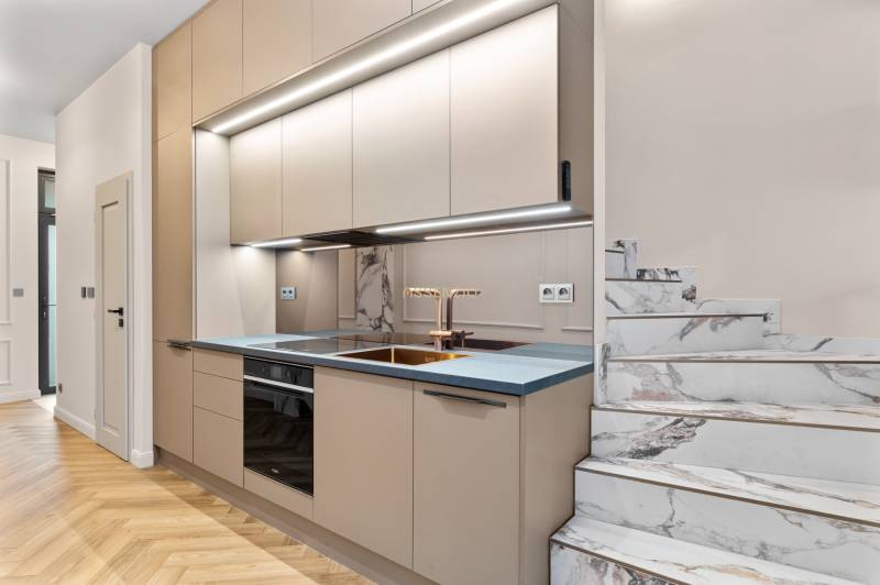 Konyha egy kétszobás lakásban márvány lépcsővel és fa dekorációjú padlóval.