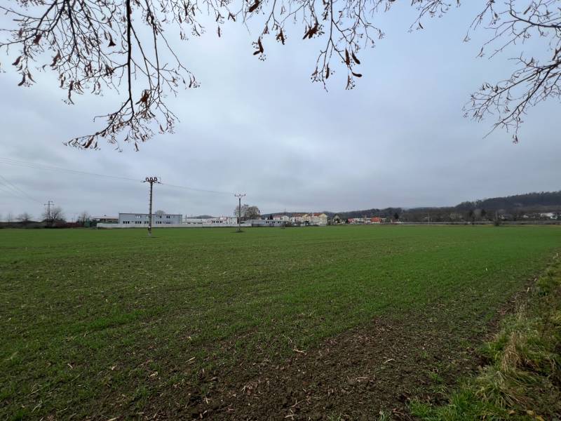 Zöldterületek és épületek Pruskéban, kereskedelmi telkek a háttérben elterülve.