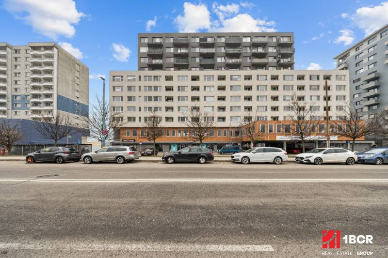 Épület a Budatinská utcában, Pozsony-Petržalka, előtte parkoló autókkal.