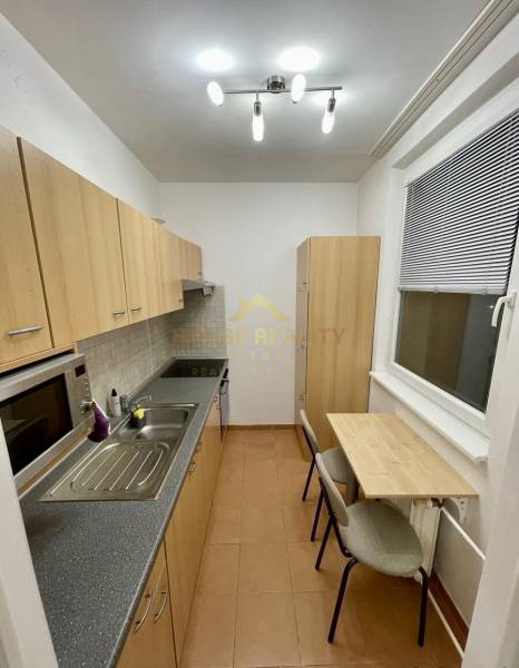 Konyha egy egyszobás lakásban minimalista asztallal és világos bútorokkal.