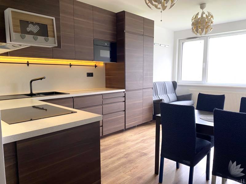 Konyha egy háromszobás lakásban sötét bútorokkal és fa dekoros padlóval.