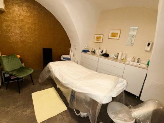 Masszázsasztal boltíves mennyezetű üzlethelyiségben, amelyhez tartozékok is tartoznak.