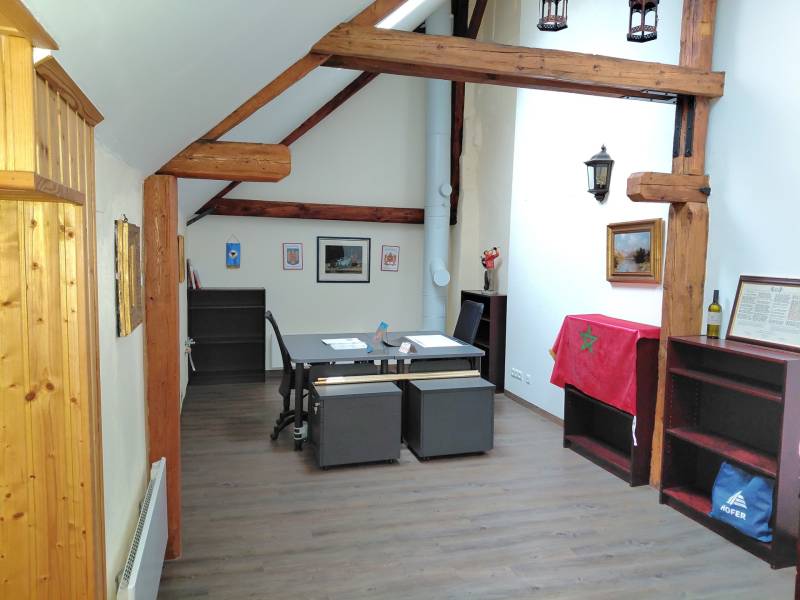 Irodák asztallal, fa gerendákkal, dekorációval és fa dekorációjú padlóval.