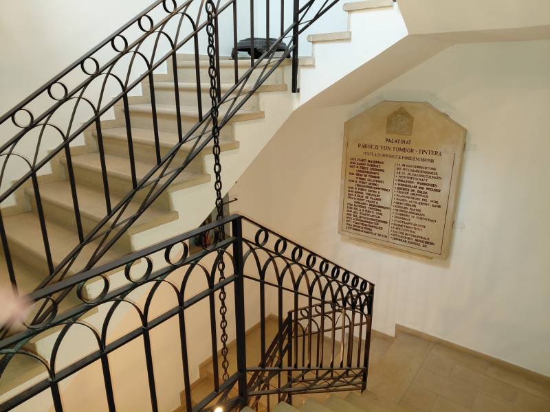 Irodai belső tér csigalépcsővel és táblával a falon, fa dekorációjú padlóval.