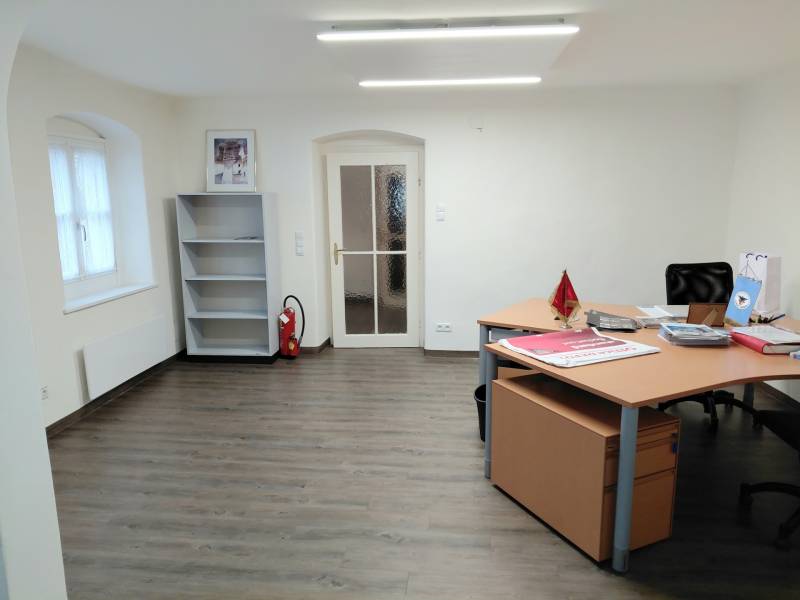 Irodák fa dekor padlóval, asztallal és üres polccal.