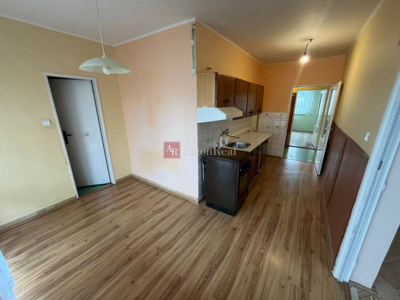 Konyha és étkező sarok egy 3 szobás lakásban fa dekoros padlóval.