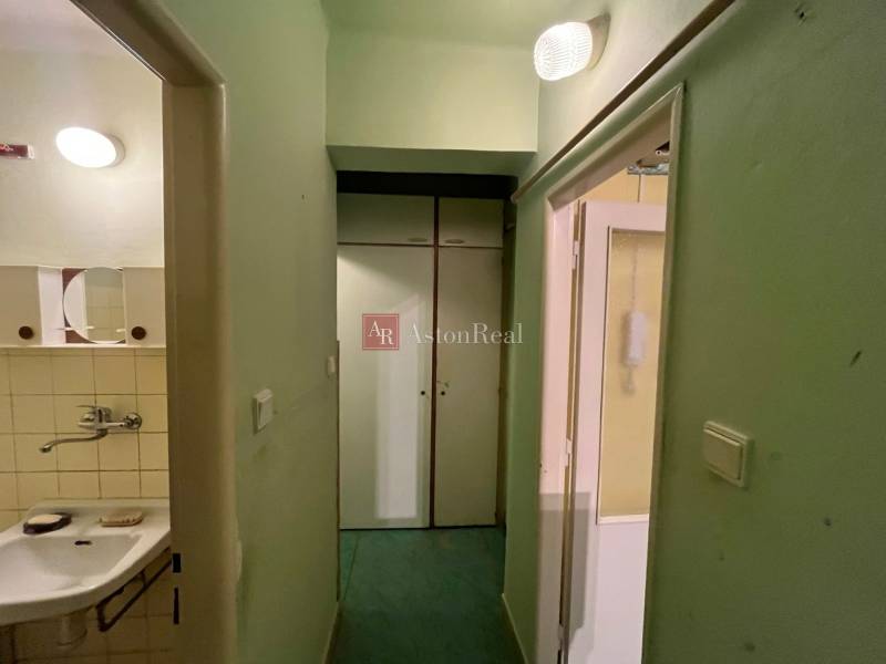 Folyosó ajtókkal és mosdóval egy háromszobás lakásban.