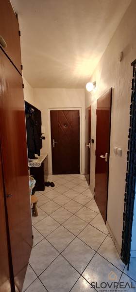 Előszoba egy 3 szobás lakásban csempével és sötét ajtókkal.