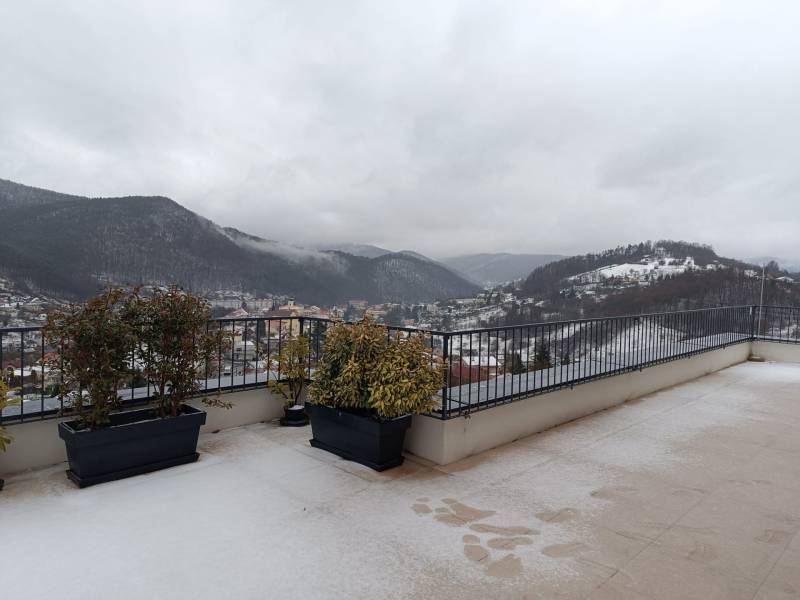 Téli kilátás a havas dombokra Újbányán egy kétszobás lakás erkélyéről.