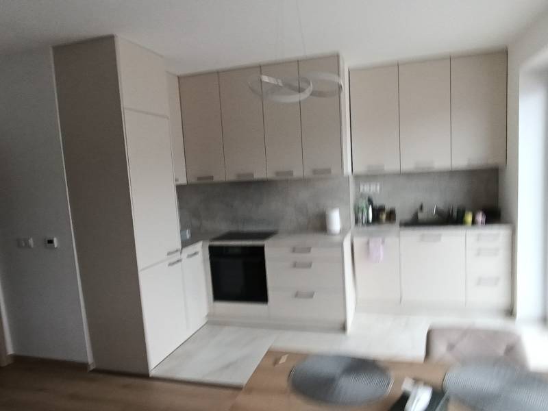 Konyha egy 2 szobás lakásban minimalista szekrényekkel és fa dekorációjú padlóval.