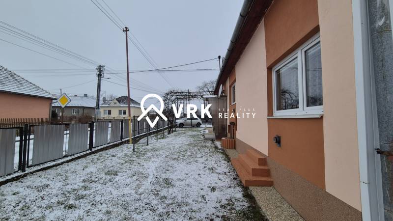 Családi ház az Új utcában, Nagy Ozorócban, havas udvarral és kerítéssel.