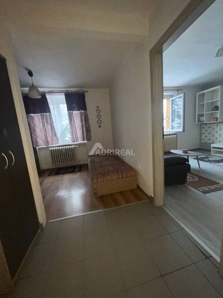 1 szobás lakás belső tere ággyal és fa dekorációjú padlóval.