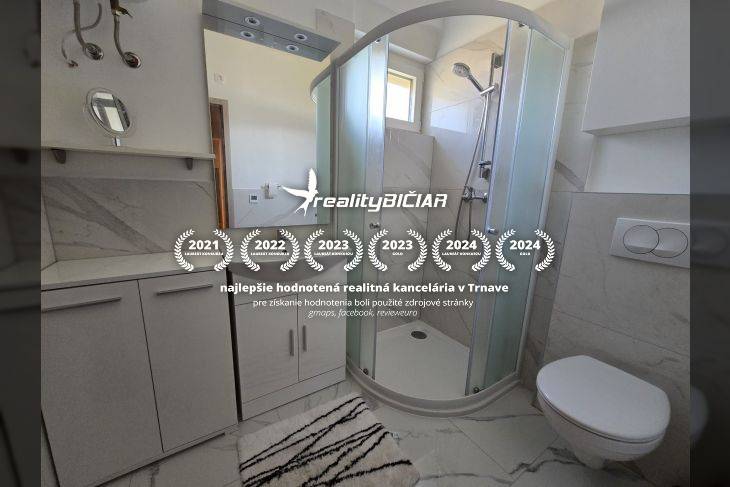 Fürdőszoba a nyaraló apartmanban modern zuhanyzóval és fehér bútorokkal.