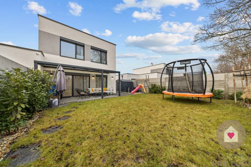 A Topoľová utcai, Rovinkában található 4 szobás lakás kertje trambulinnal és terasszal.