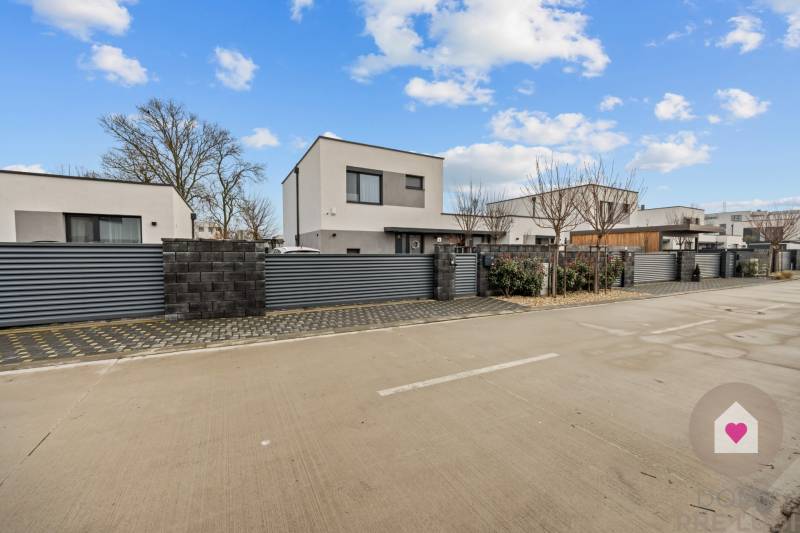 Új építésű házak garázzsal a Topoľová utcában, Rovinkában, modern kerítéssel körülvéve.