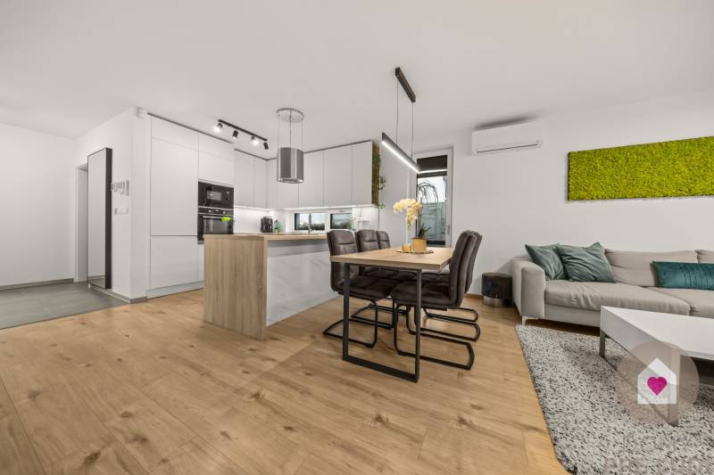 Konyha egy 4 szobás lakásban fa dekor padlóval és étkezőasztallal.