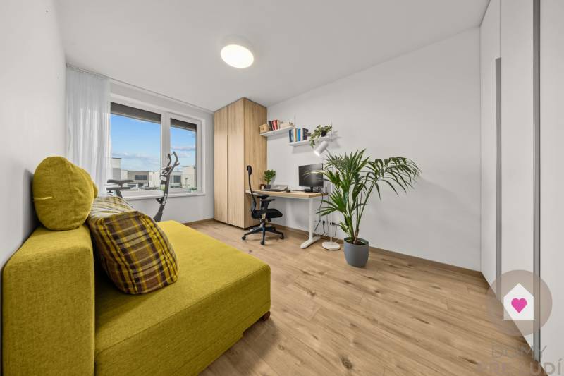 Dolgozószoba egy négyszobás lakásban dekoratív padlóval, sárga kanapéval és nagy ablakkal.