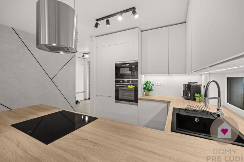 Konyha egy 4 szobás lakásban, fa dekorációjú padlóval és modern konyhai felszereléssel.