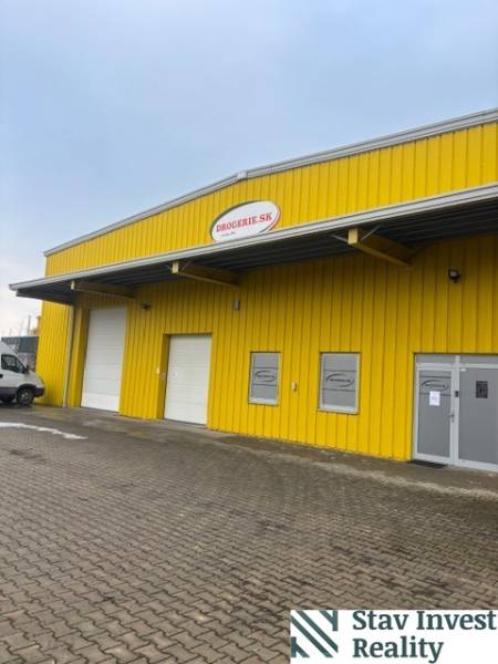 Sárga raktárépület és csarnok a Poľná úton, Szencen, bejárati kapukkal.