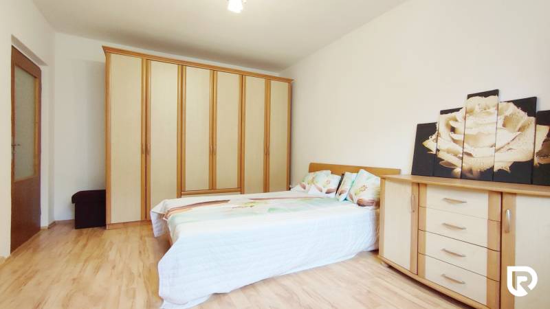 Hálószoba emeletes ággyal, gardróbbal, komóddal és fa dekorációjú padlóval egy kétszobás lakásban.