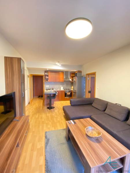 Nappali egy kétszobás lakásban, fa mintás padlóval és kanapéval.