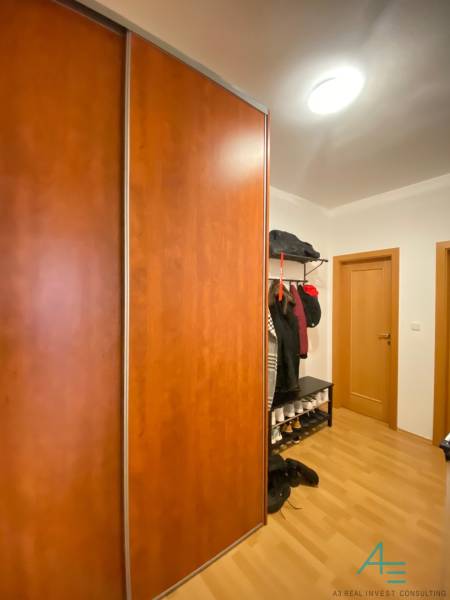 Két szobás lakás előszobája fa dekor padlóval és nagy gardróbszekrénnyel.