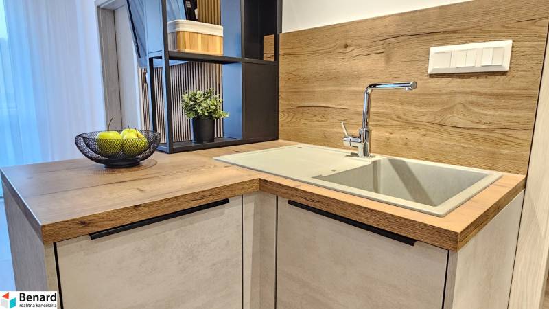 Konyhapult az egyszobás lakásban mosogatóval és fa dekoros padlóval.