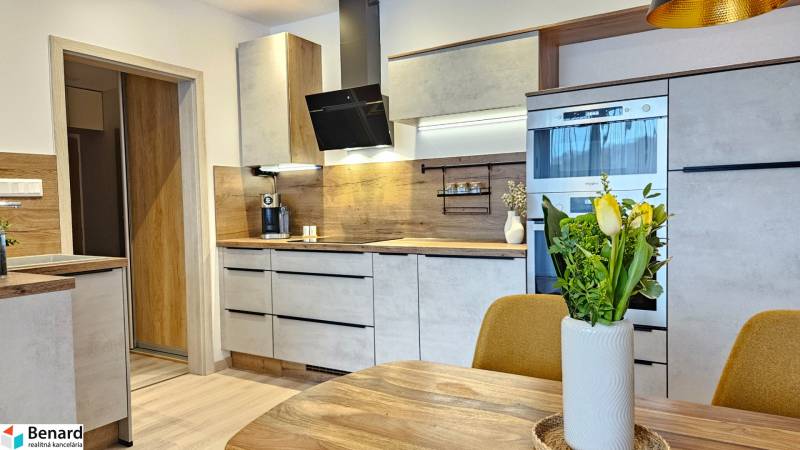 Konyha egy egyszobás lakásban fa dekor padlóval és modern felszereléssel.