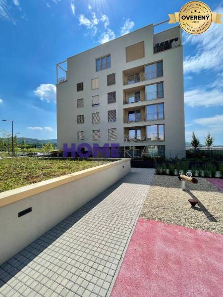 Lakókomplexum Zdenka Schelingová utcában, Pozsonyban, Dévényújfalu, zöldterülettel és játszótérrel.