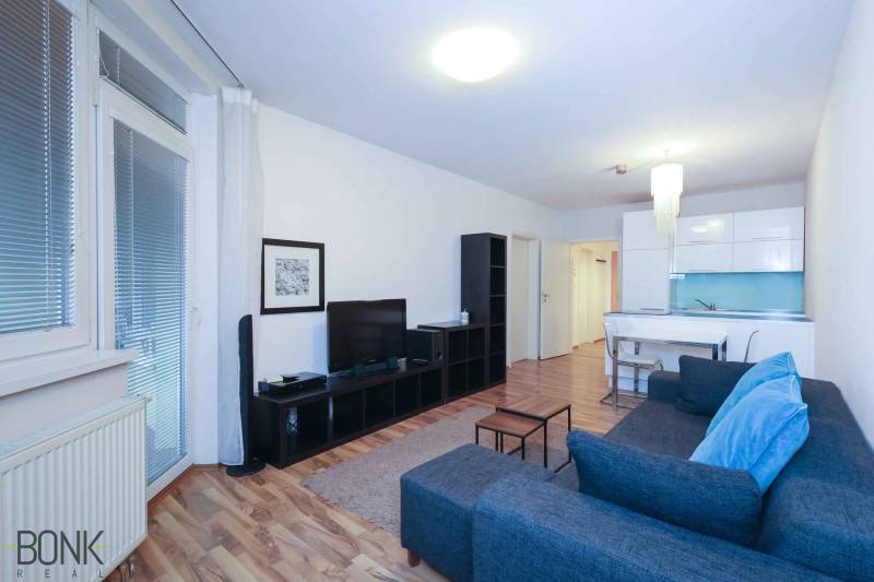 Két szobás lakás nappalija fa dekor padlóval és stílusos bútorokkal.