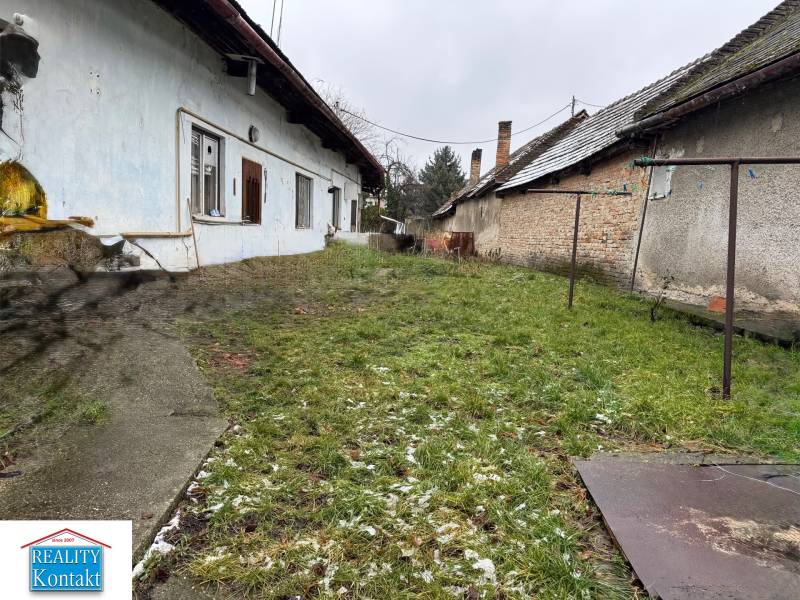 Családi ház kerttel a Komenského utcában, Surányban, az eredeti épületek mellett.