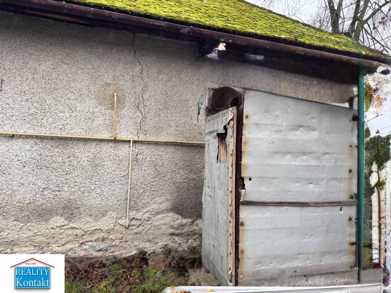 Családi ház a Komenského utcában, Surányban, régebbi homlokzattal és mohával a tetőn.