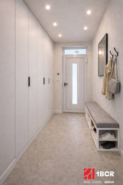 Folyosó a családi házban fogassal, paddal és beépített szekrénnyel.