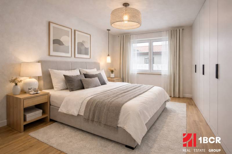 Világos hálószoba nagy ággyal, éjjeliszekrényekkel és fa dekorációjú padlóval egy családi házban.