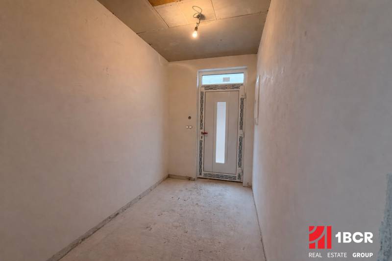 Folyosó egy családi házban egyszerű világítással és műanyag ajtókkal.