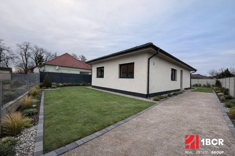 Családi ház Nagy-Grobban gyepesített udvarral, kavicsos járdával és rendezett kerttel.