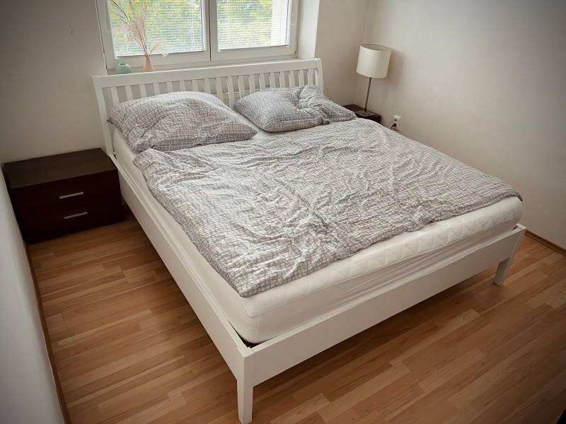 Hálószoba egy kétszobás lakásban fa dekor padlóval és franciaággyal.