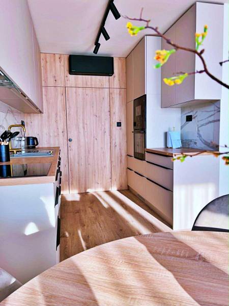 Konyha egy háromszobás lakásban fa dekorációval és beépített készülékekkel.